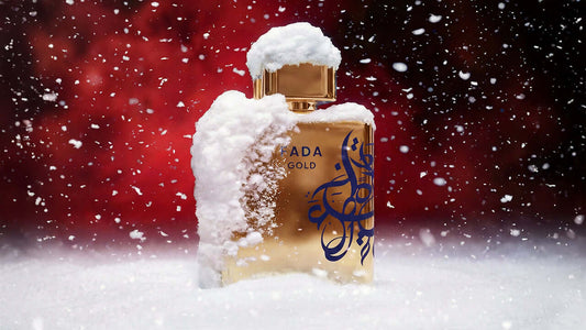 Best Perfumes for Men in Winter - Prada Gold perfume bottle covered in snow with a festive background.